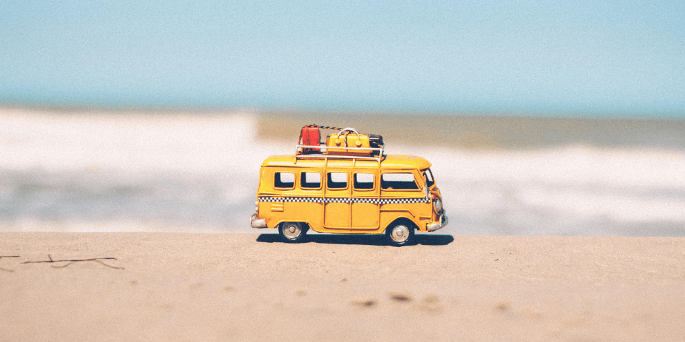 A bus loaded with luggage at the beach.