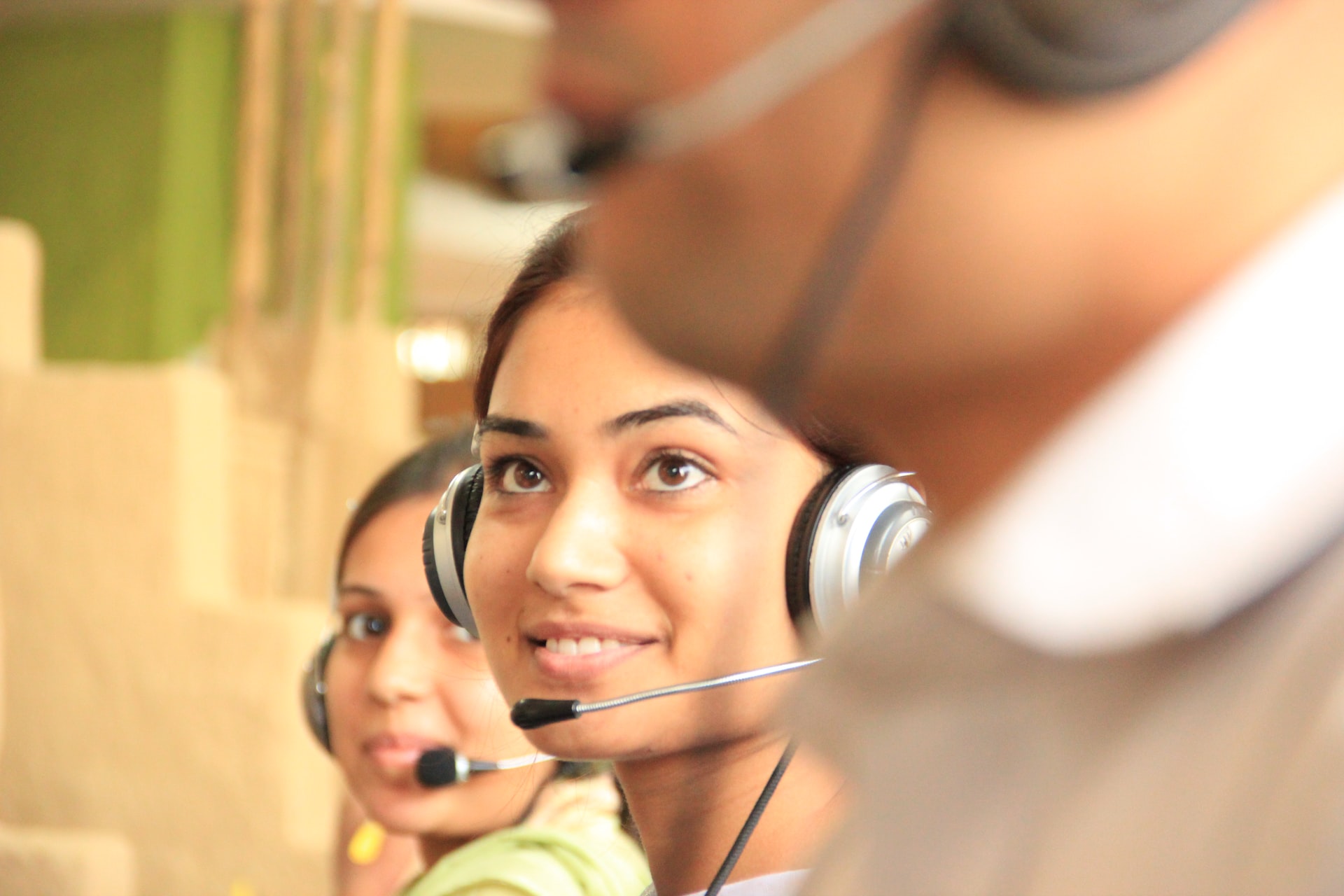 Smiling agents with headsets to whom you can outsource eCommerce customer service.