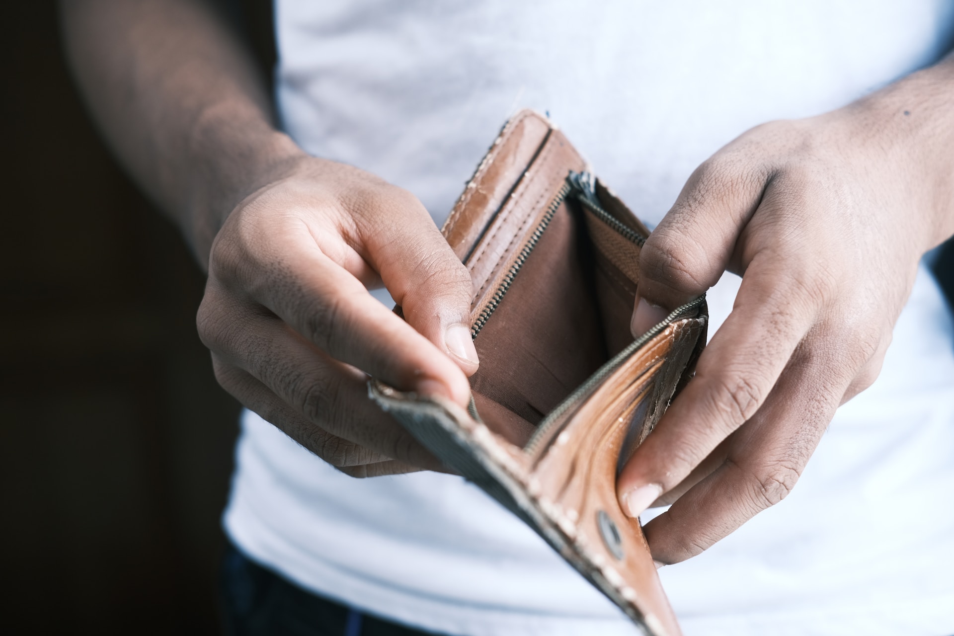 A man opening an empty wallet.