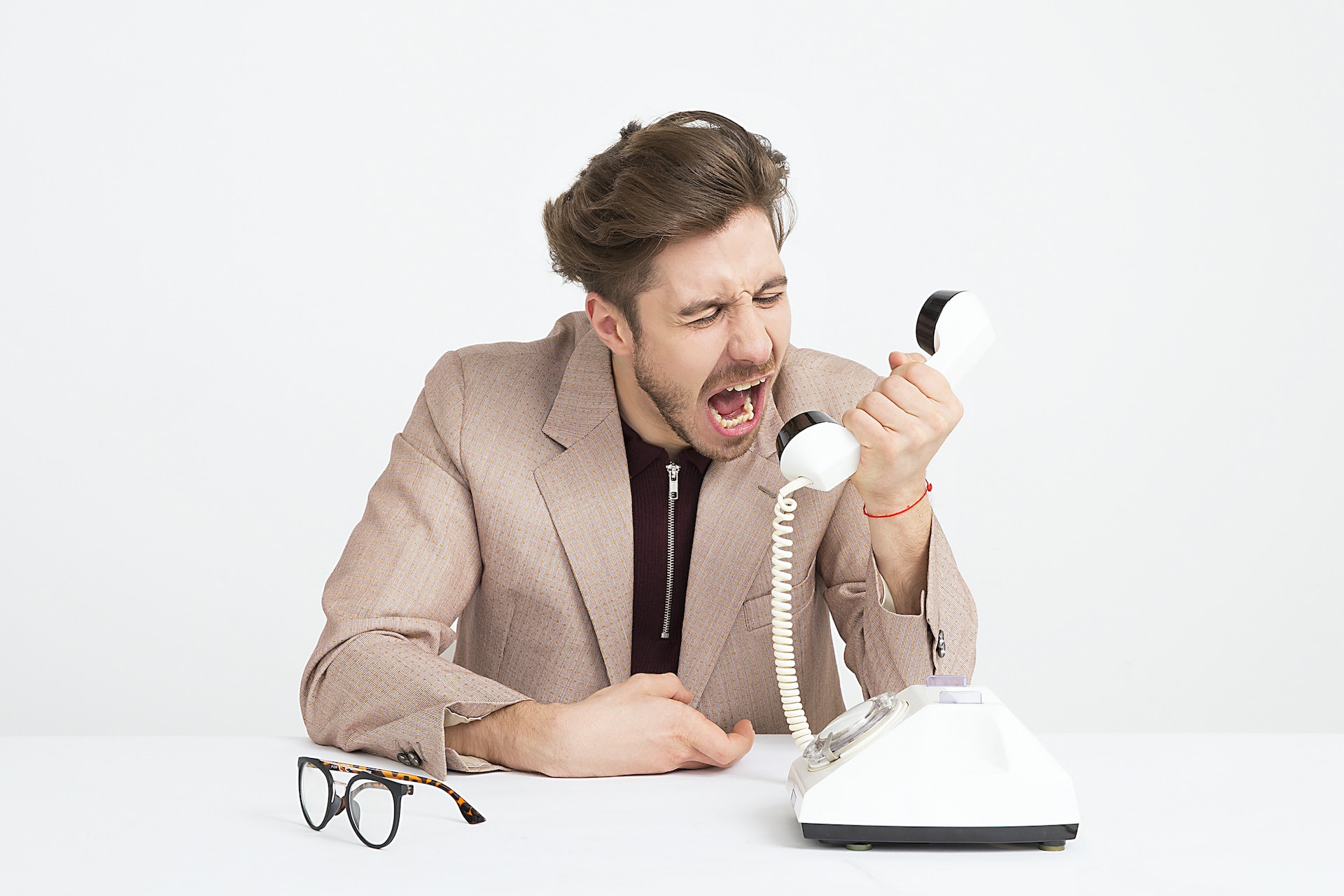 A man screaming into a phone about call center outsourcing