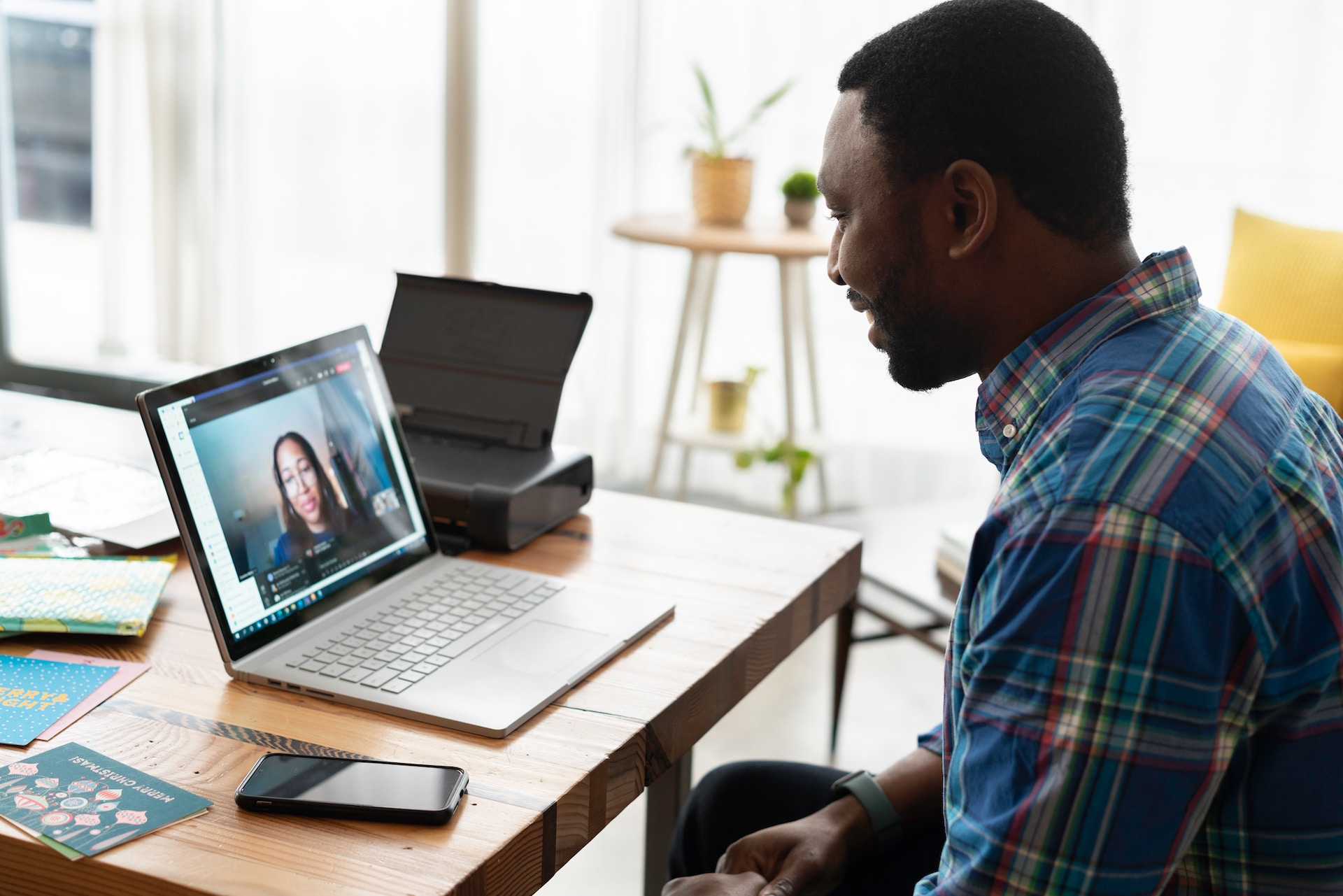 A man communicating with a woman via video call about outsourcing strategies