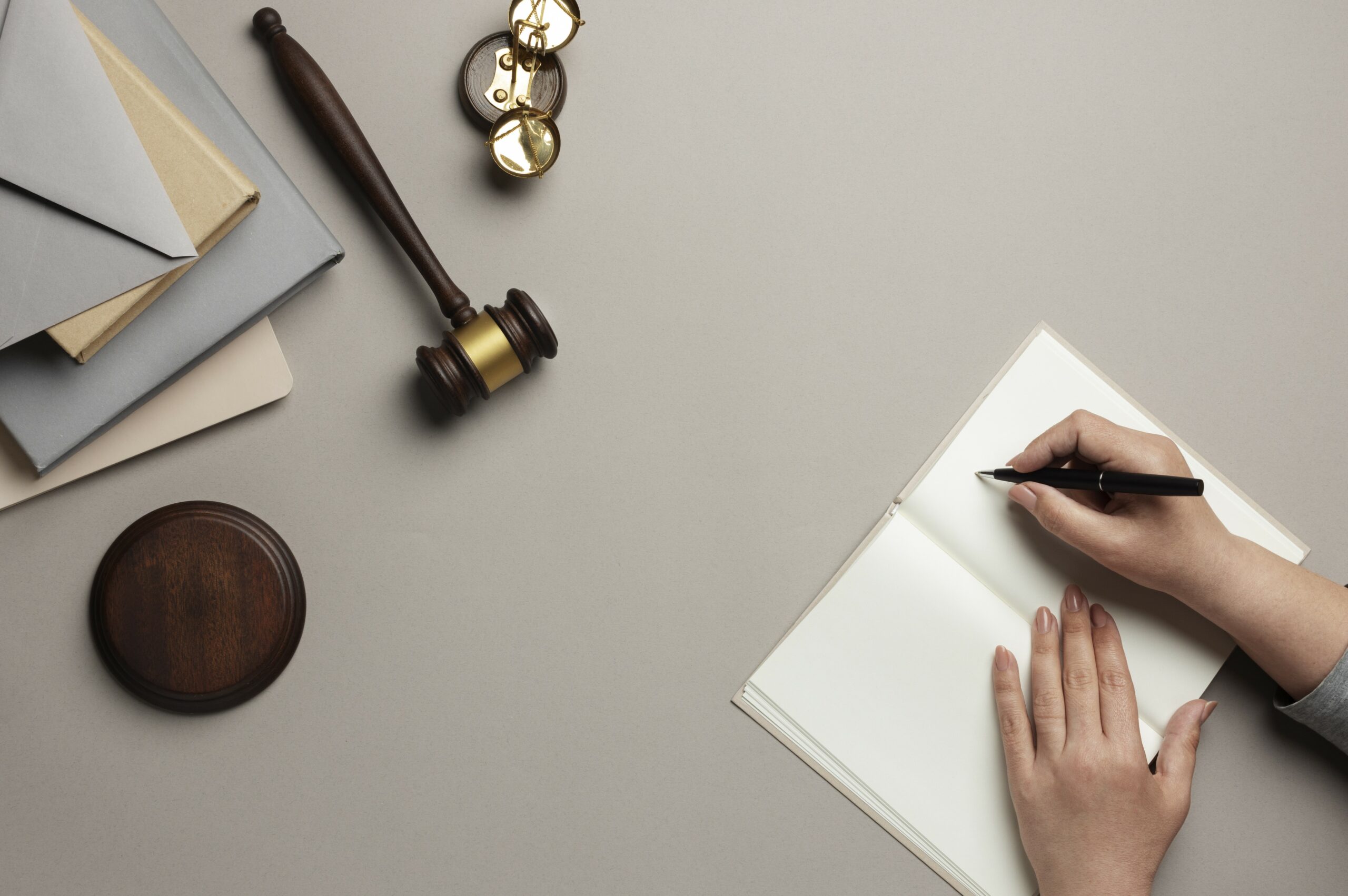 A lady with a gavel on her desk writing on paper.